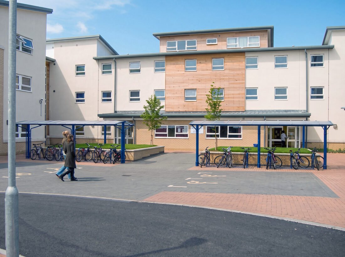 The outside of the building with covered bike shelters