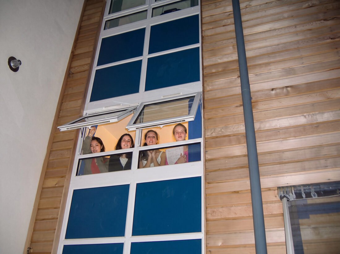 Students looking out of a window at the building